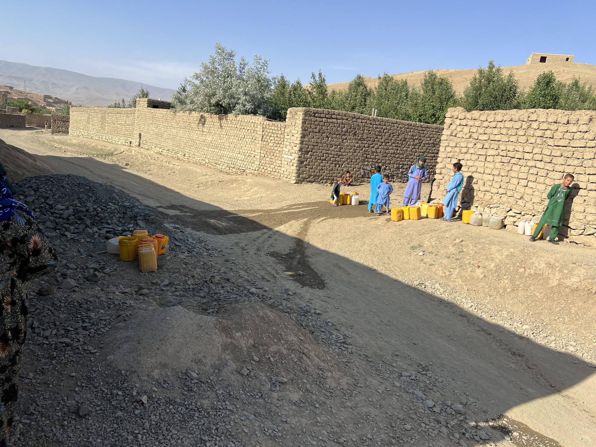 Wide road and mud-brick walls in Ghor with mountains beyond